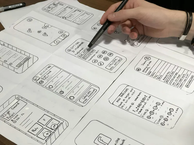 Designer sketching interface wireframes on paper